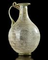 A ROMAN LIGHT GREEN GLASS JUG,1ST CENTURY A.D.