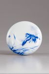 A blue and white circular paste box and cover