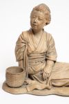 A soft paste light brown figure of a reclining farm girl
