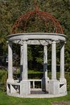 A CARVED LIMESTONE AND WROUGHT IRON MOUNTED ROTUNDA, LATE 20TH CENTURY