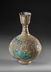 A KASHAN TURQUOISE GLAZED MOULDED BOTTLE VASE, PERSIA, 12TH CENTURY