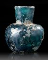 A MOULDED BLUE GLASS BOTTLE, NISHAPUR, NORTH-EAST PERSIA, 9TH CENTURY