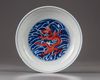 A Chinese iron-red-decorated blue and white 'dragon' dish