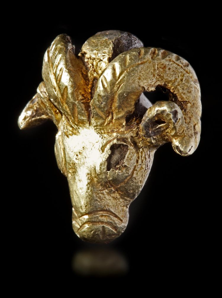 A NEO-ELAMITE GOLD FOIL-COVERED SILVER RAM HEADED AMULET PENDANT, CIRCA 1100-540 B.C.