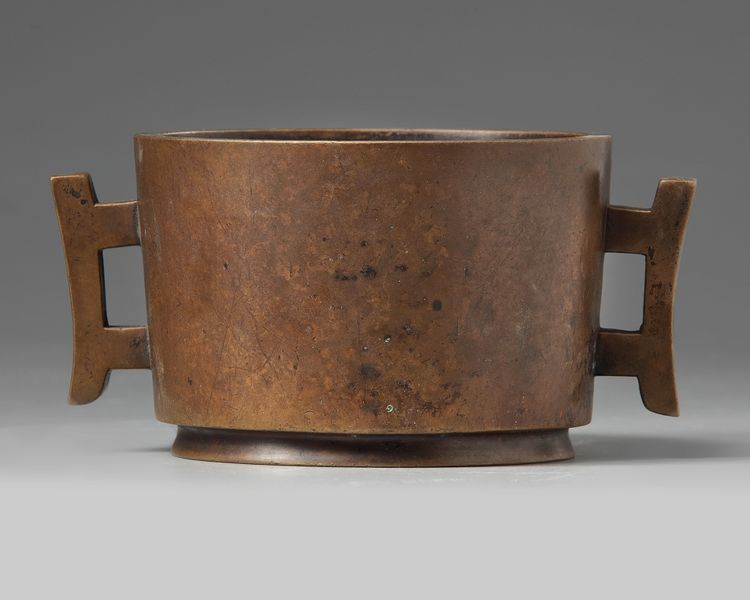 A CHINESE BRONZE TWIN-HANDLED CENSER
