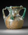 A ROMAN FOUR-HANDLED GREEN GLASS JAR, CIRCA 3RD CENTURY A.D.