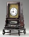 A Chinese gilt bronze table clock in a hongmu case and stand