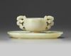 A Chinese white jade ‘twin chilong’ cup stand and a pale celadon jade cup