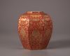 A coral-red ground gilt floral-decorated jar
