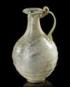 A ROMAN LIGHT GREEN GLASS JUG,1ST CENTURY A.D.