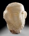 A CARVED ALABASTER FUNERARY PORTRAIT WITH INSCRIPTION TO THE NECK, LATE 1ST MILLENNIUM BC