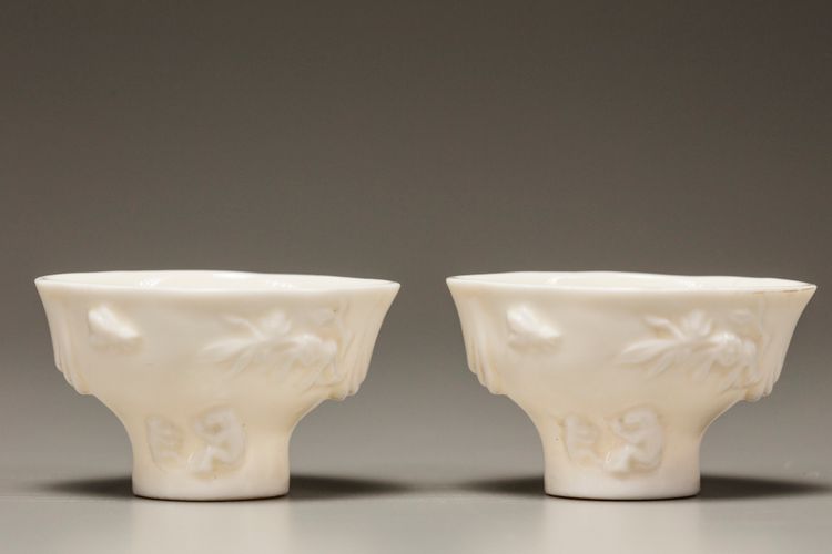 A pair of white-glazed libation cups