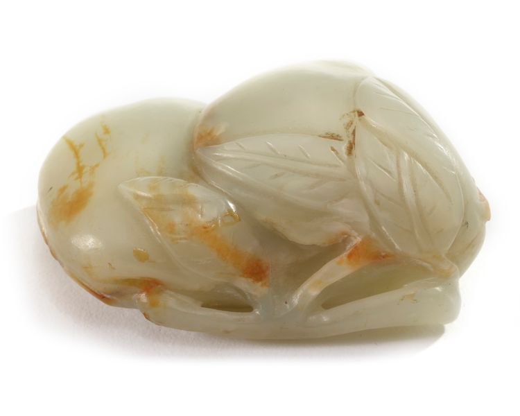 A Chinese celadon and russet jade carving of two peaches