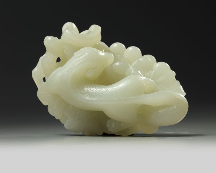 A large Chinese white jade ‘squirrel and grapes’ carving