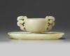 A Chinese white jade ‘twin chilong’ cup stand and a pale celadon jade cup