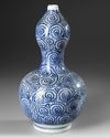 A JAPANESE BLUE AND WHITE  DOUBLE- GOURD SAKE VASE, WITH OCTOPUS AND KARAKUSA, LATE EDO PERIOD, 18TH CENTURY