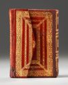 A SMALL RED LEATHER-BOUND QURAN