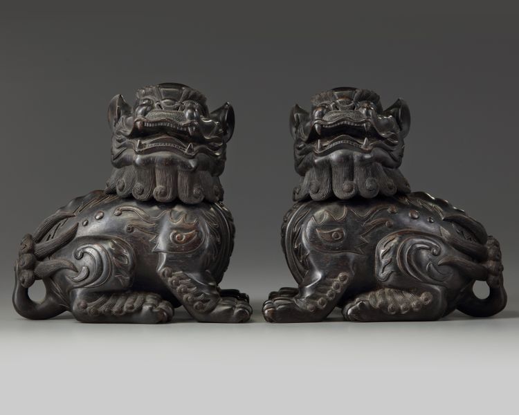 A pair of Chinese carved zitan wood Buddhist lions