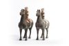 A pair of Chinese painted grey pottery figures of equestrians