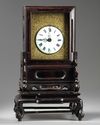 A Chinese gilt bronze table clock in a hongmu case and stand