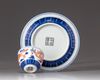 A small Chinese iron-red-decorated blue and white 'dragon' cup and saucer