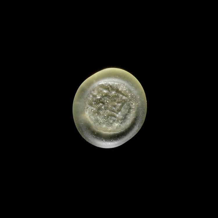 A FATIMID GLASS WEIGHT OF HALF DIRHAM, EGYPT AL-ZAHIR ( 412-427 AH/ 1021-1036 AD)