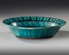 A RAQQA TURQUOISE-GLAZED POTTERY DISH, SYRIA, EARLY 13TH CENTURY