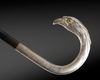 A SILVER-MOUNTED BLACK WOOD WALKING CANE WITH BIRD-HEAD HANDLE