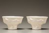 A pair of white-glazed libation cups