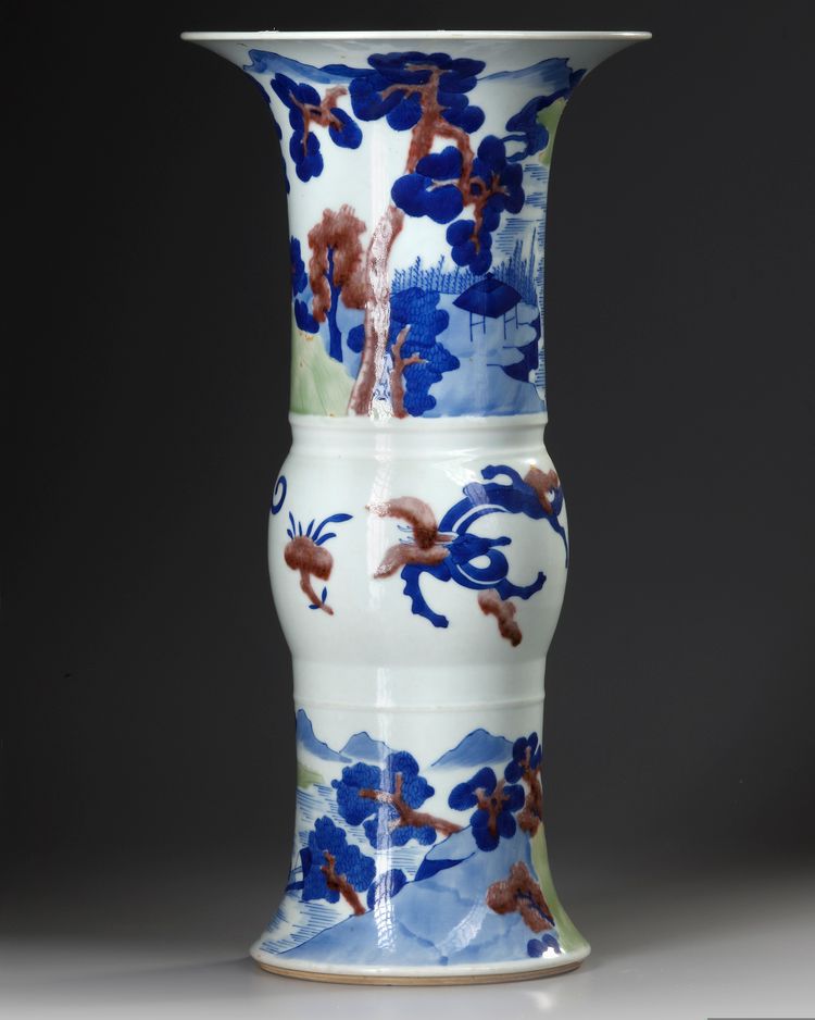 A CHINESE UNDERGLAZE BLUE, COPPER-RED AND CELADON-GLAZED CARVED BEAKER VASE, GU