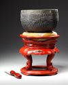 A JAPANESE TEMPLE BELL ON RED LACQUERED STAND WITH PILLOW 
