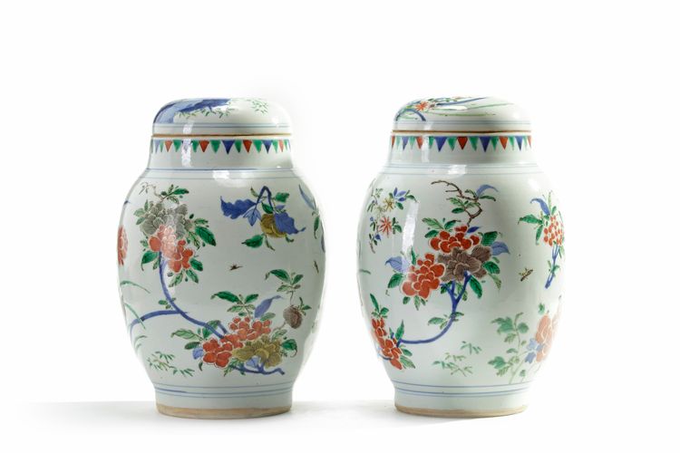 A pair of Chinese wucai 'floral' ovoid vases and covers