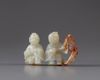 A pale jade carving of two boys with a wooden stand