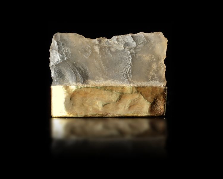 A TRANSLUCENT HARD STONE RAZOR MOUNTED IN A GOLD CAP