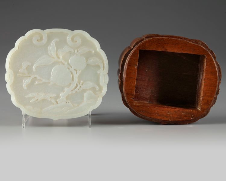 A Chinese pale celadon jade 'peach' plaque on a hongmu box