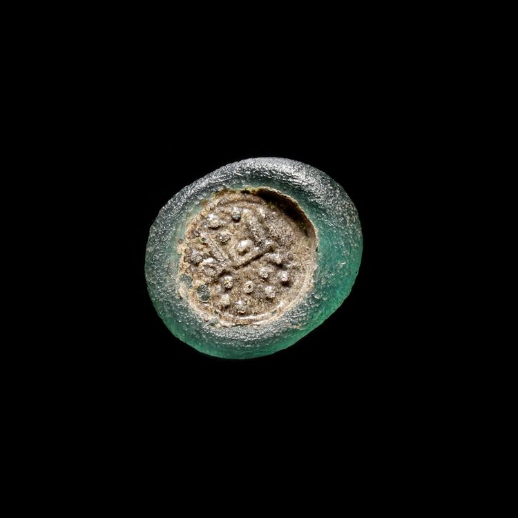 A FATIMID GLASS WEIGHT OF HALF DIRHAM, EGYPT AL-ZAHIR ( 412-427 AH/ 1021-1036 AD)