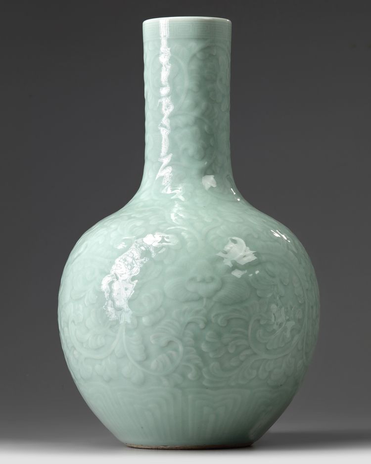 A CHINESE CARVED AND MOULDED CELADON-GLAZED BOTTLE VASE