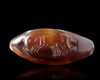 A SARDONYX CARVED BEAD WITH AN INTAGLIO OF A BIGA ADDED IN ROMAN TIMES, 1ST MILLENIUM BC AND 2ND CENTURY AD