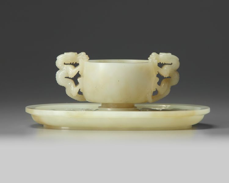 A Chinese white jade ‘twin chilong’ cup stand and a pale celadon jade cup