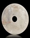 A CHINESE BI DISC DECORATED WITH A BORDER OF FOUR ANIMAL HEADS INTERTWINED TO FORM A PATTERN, LATE EASTERN ZHOU OR HAN PERIOD (c.471-221 BC)