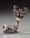 AN ELAMITE SILVER RECLINING STAG, CIRCA 2ND CENTURY B.C.