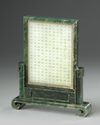 A Chinese pale celadon jade plaque in a spinach green jade stand