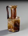 AN AMBER MOLDED GLASS JUGLET, EASTERN MEDITERRANEAN, 1ST–3RD CENTURY AD