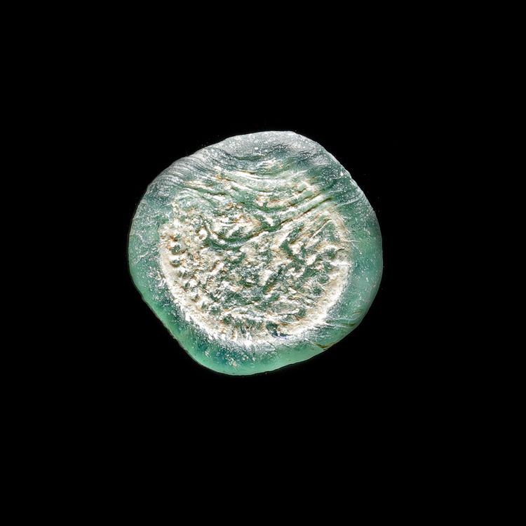 A FATIMID GLASS WEIGHT, AL-HAKIM BI-AMR ALLAH (386AH-411AH/ 996AD-1021AD)