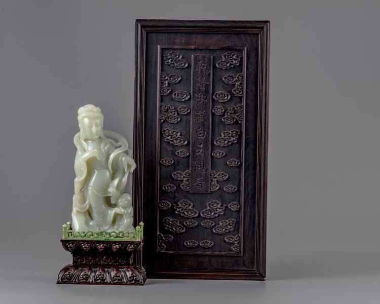 A pale jade carving of a guanyin in a zitan box and stand