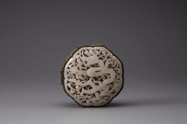 A white jade 'dragon' plaque inset into a gilt filigree box