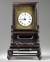 A Chinese gilt bronze table clock in a hongmu case and stand