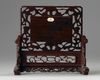 A Chinese famille verte plaque inset into a wooden table screen