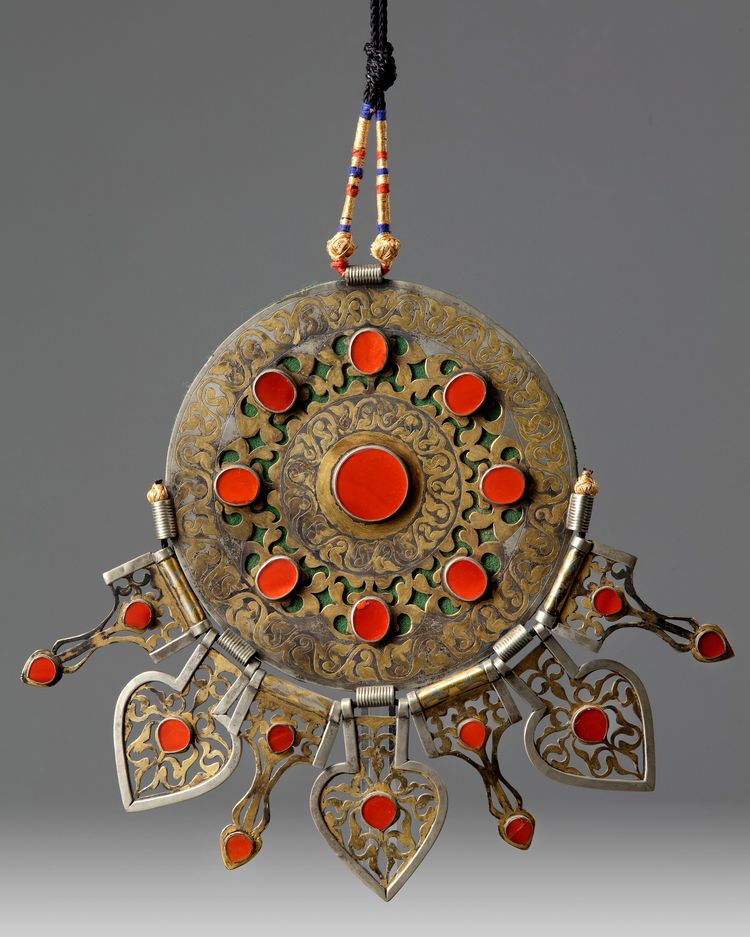 An Islamic gilt and silver inlaid pendant