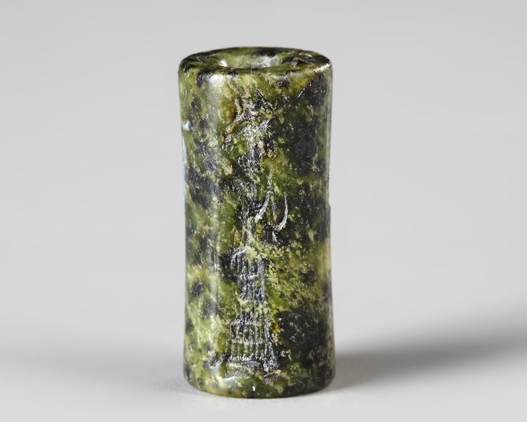 A WESTERN ASIATIC GREEN SERPENTINE CYLINDER SEAL, CIRCA 1900-1700 B.C.